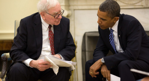 Warren Buffet und Barack Obama sitzen sich in Anzügen gegenüber und unterhalten sich