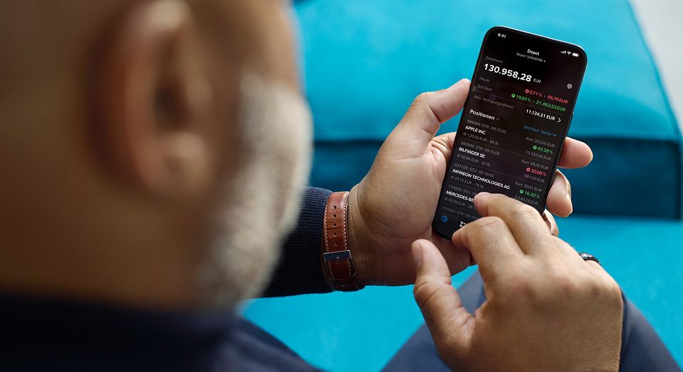 Nahaufnahme eines Mannes der auf seinem Smartphone tradet