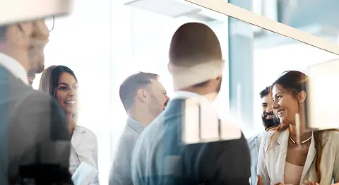 Eine Gruppe von Menschen unterhält sich im Büro