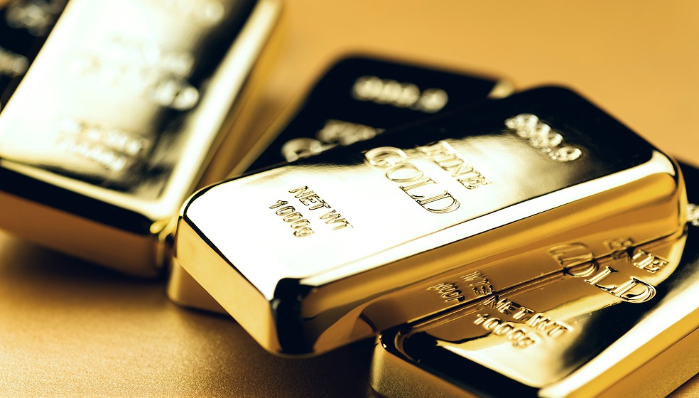 Blick von oben auf einen Tisch, auf dem mehrere glänzende Goldbarren liegen