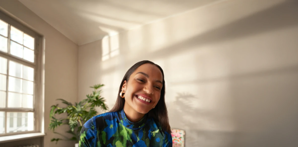 Lachende Frau in buntem Oberteil mit Zahnlücke