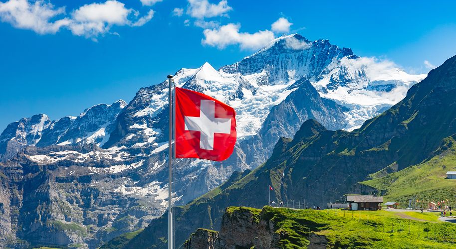 Schweizer Flagge vor Bergen mit Schnee