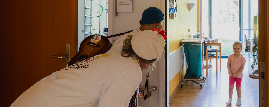Zwei Clowns besuchen ein Kind in der Kinderklinik